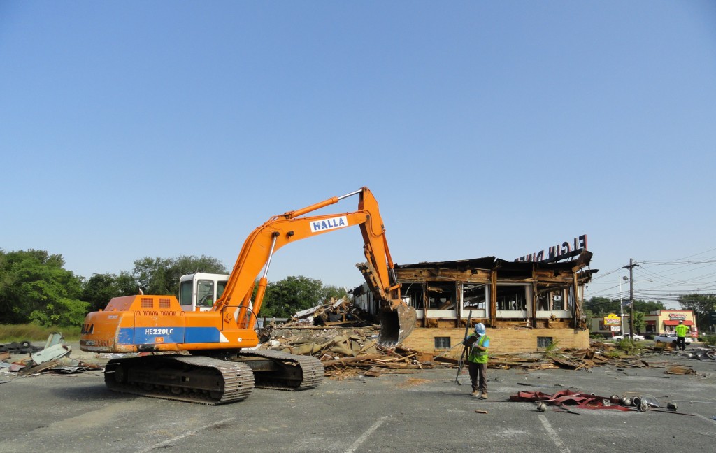 A backhoe sifts through pieces of the antique Elgin Diner in Camden City. Credit: Matt Skoufalos.