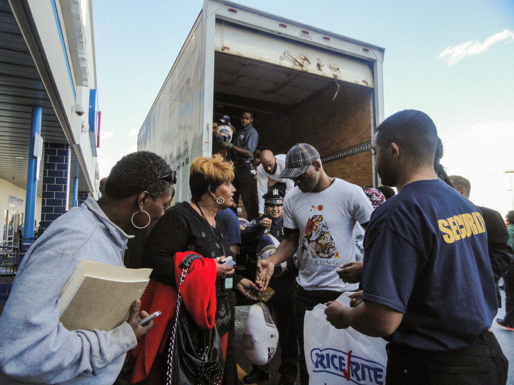 Boxer Bernard Hopkins hands a turkey to Camden resident Karen Pettiford. Credit: Matt Skoufalos.