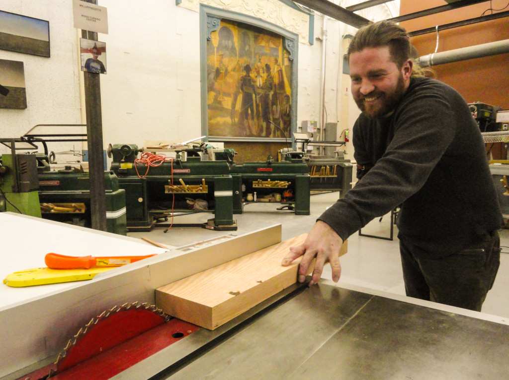 Faulseit demonstrates his new arm in the woodshop. Credit: Matt Skoufalos.