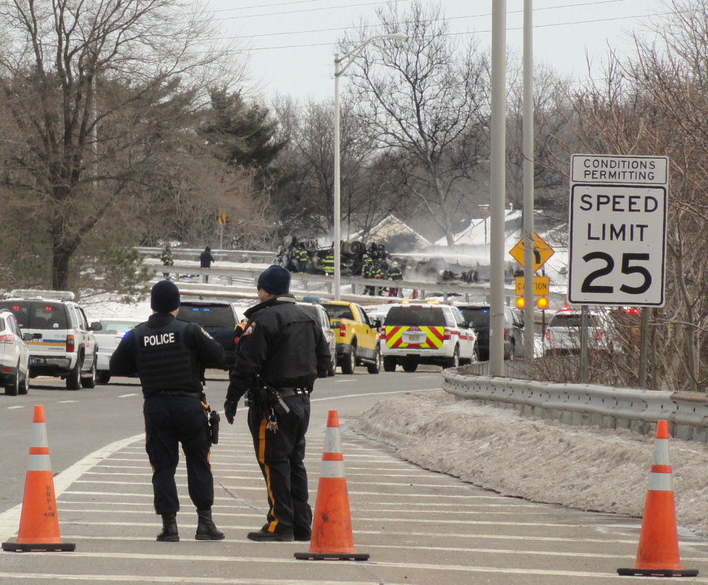 Officers watch as fire crews extinguish the truck. Credit: Matt Skoufalos.