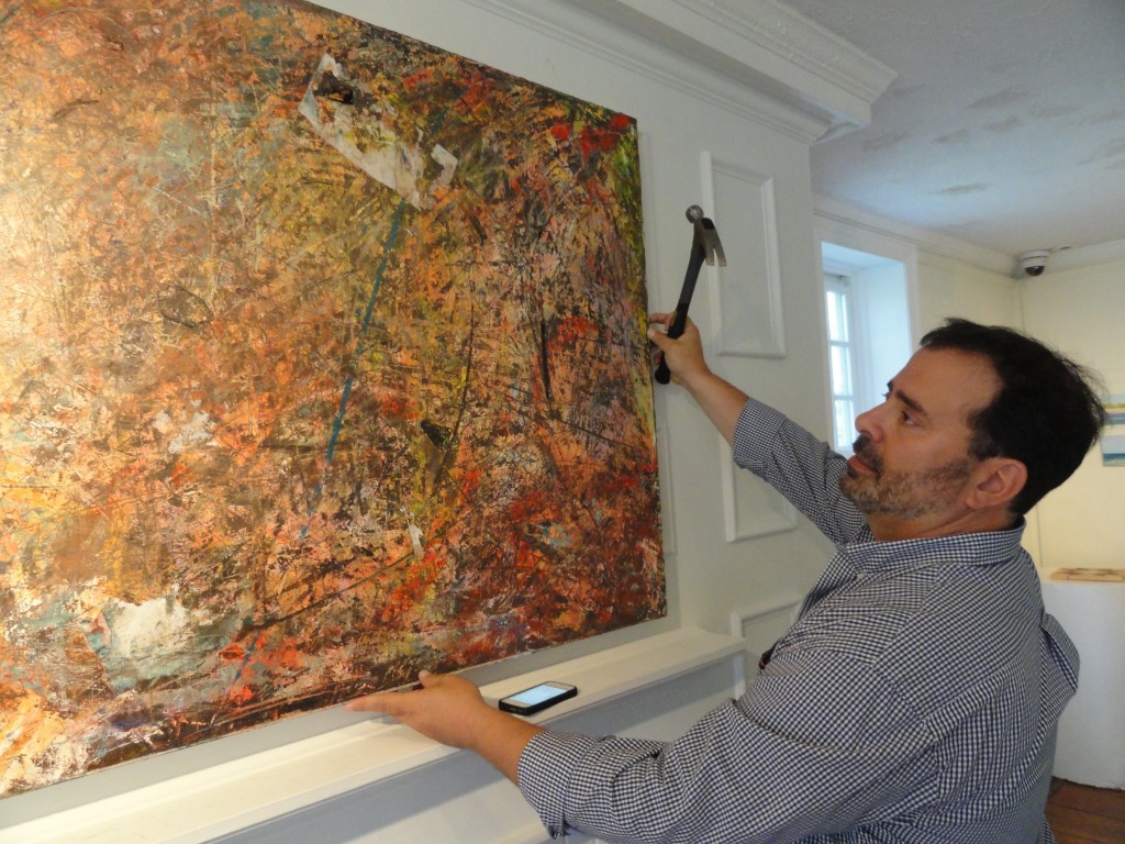 Hochgertel hangs a painting. Credit: Matt Skoufalos.